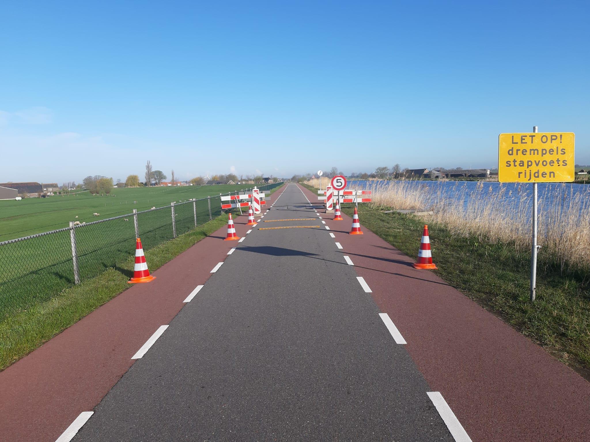 Wegafzetting bord en verkeerskegel slangbrug