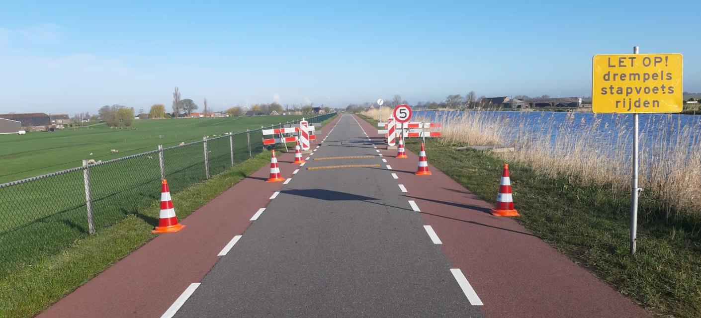 Wegafzetting bord en verkeerskegel slangbrug