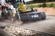bobcat met bezem en opvangbak asfalt reinigen 